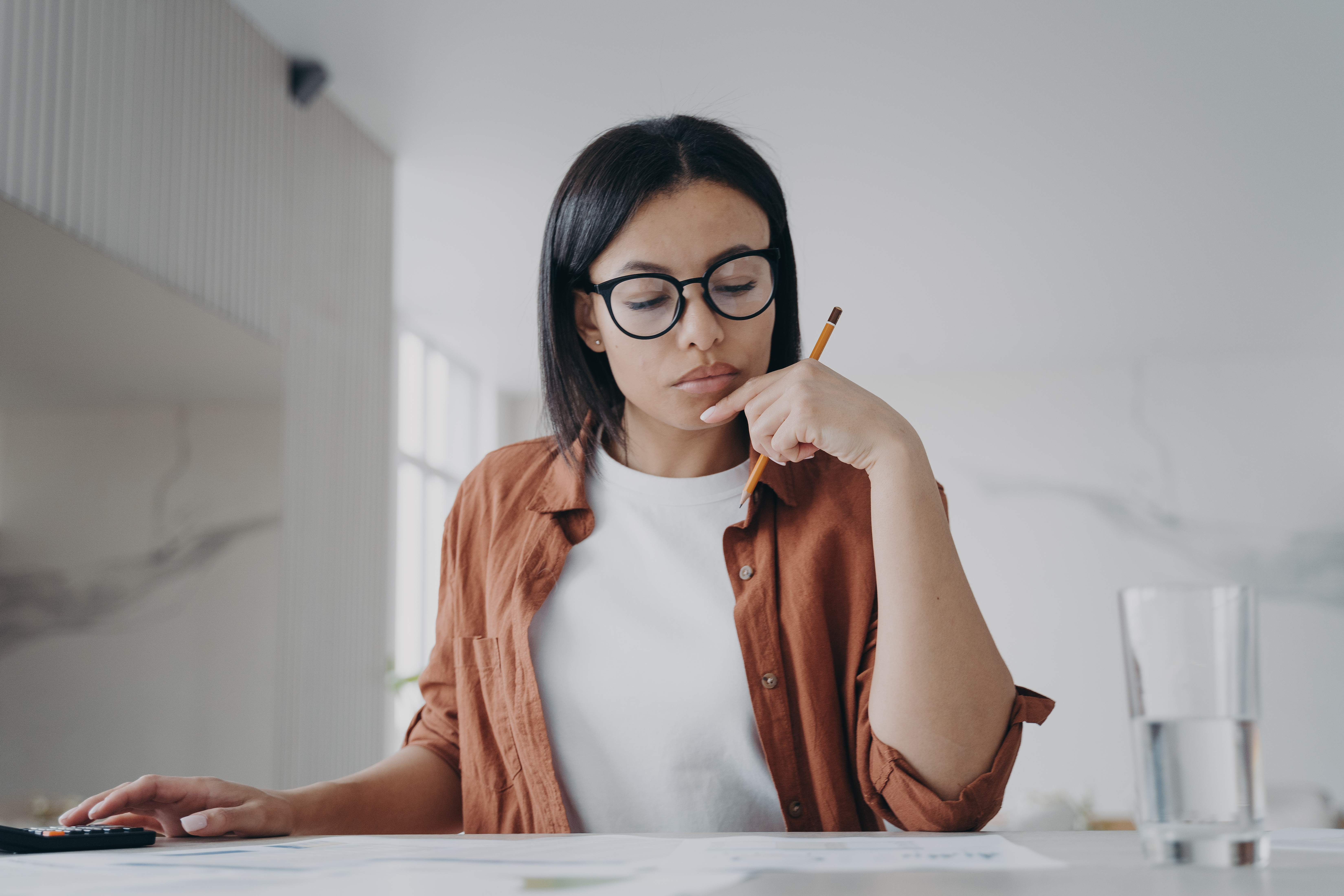 Female housewife in glasses calculates expenses, planning household budget for saving money at home